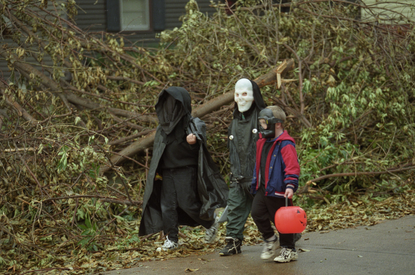 Trick-or-treaters pass trees downed in the October 26, 1997 storm. Power lines were still down in several Omaha neighborhoods, so many children went store to store instead of door to door for their goodies. People were urged to go trick or treating during daylight hours in neighborhood that were deemed safe.